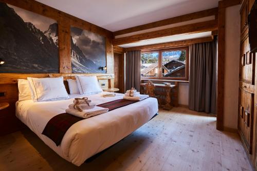 a bedroom with a large bed with towels on it at Hotel Europa in Cortina dʼAmpezzo