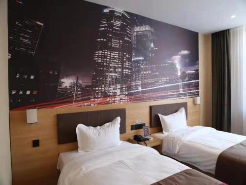 una habitación de hotel con 2 camas y una gran pintura en la pared en Thank Inn Chain Hotel shandong binzhou bincheng district vocational college, en Binzhou