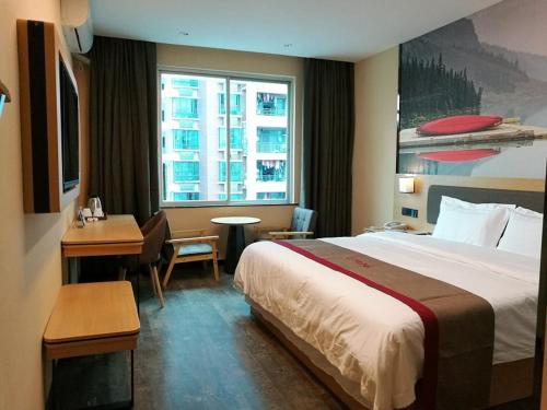 a hotel room with a large bed and a window at Thank Inn Chain Hotel guangxi liuzhou wal-mart jinfudi in Liuzhou