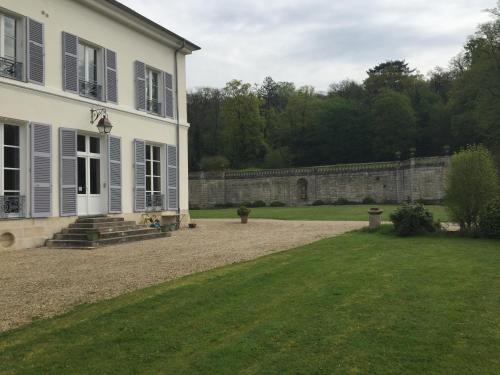 a house with a stone wall and a yard at La Grande Maison in Seine-Port