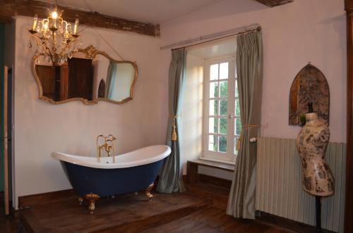 une salle de bain avec une grande baignoire et une fenêtre dans l'établissement Chateau Gros Puy, Petit Chateau chambre d'hote, à Abjat