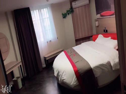 a bedroom with a large bed and a window at Thank Inn Chain Hotel anhui fuyang funan county government in Fuyang
