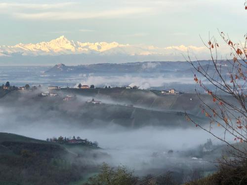 a foggy valley with snowy mountains in the background at Cà 'd Langa B&B in Treiso