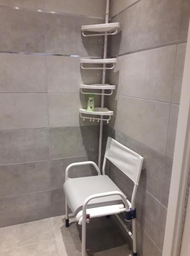 une chaise blanche dans une chambre avec un mur dans l'établissement Les violettes, à Menton