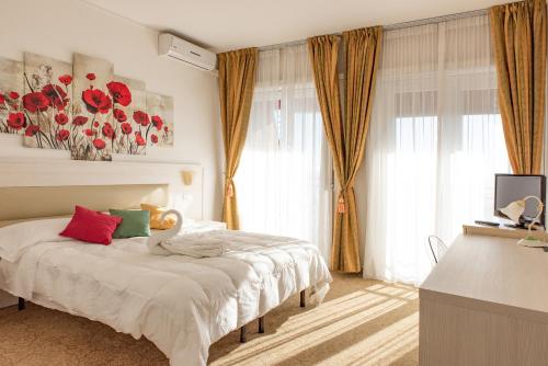 a bedroom with a bed with red and green pillows at Hotel Principe in Sanremo