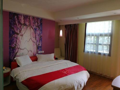 una camera con un grande letto e una finestra di Thank Inn Chain Hotel guizhou anshun huangguoshu scenic area ad Anshun