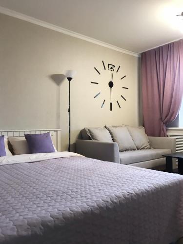 1 dormitorio con 1 cama y reloj en la pared en •КВАРТИРА НА ДРУЖБЫ НАРОДОВ•, en Kogalym