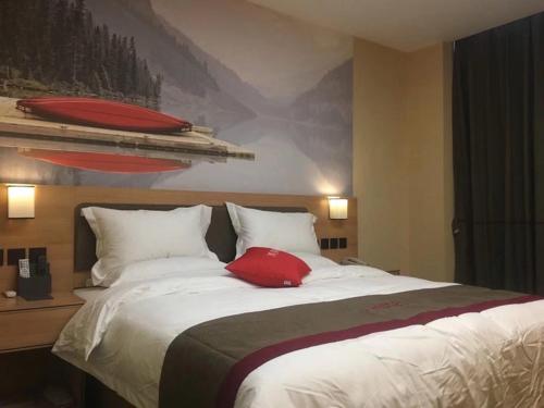 a bedroom with a bed with a red pillow on it at Thank Inn Chain Hotel inner mongolia bayannaoer urat qianqi huifeng square in Xishanzui