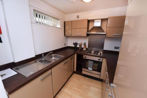 a small kitchen with a sink and a stove at Dreamhouse Apartments Manchester City Centre in Manchester