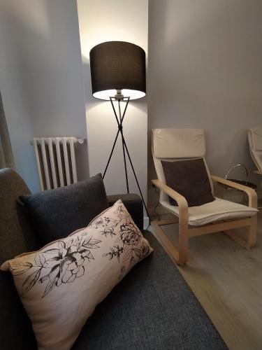 a living room with a chair and a pillow and a lamp at La Parada de Echegaray in Zaragoza