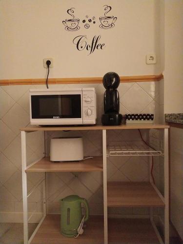a microwave on a table with a coffee sign on a wall at La Parada de Echegaray in Zaragoza