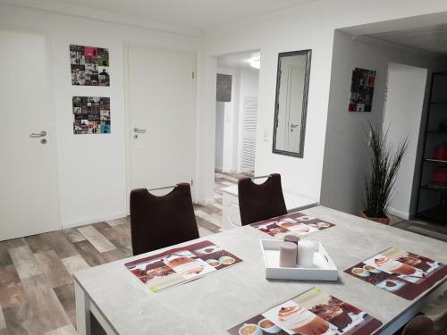 a dining room table with chairs and photographs on it at Ferienwohnung Lindenstraße 8L in Flessenow