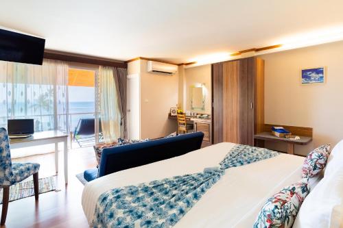 a hotel room with a bed and a balcony at Palm Coco Mantra in Lamai