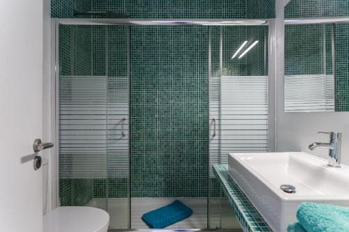 une salle de bain avec un lavabo et une douche en verre dans l'établissement WOW Flat 200m Beach, 10min Downtown, Terrace With Sea View, à Lagos