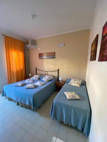 two beds in a room with blue sheets at Hotel Noto Marina Stella Marina - B&B in Noto Marina