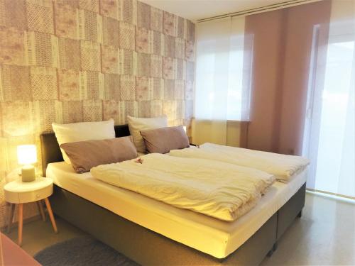 a bedroom with a large bed with white sheets at Ferienwohnungen Koller in Bodenmais
