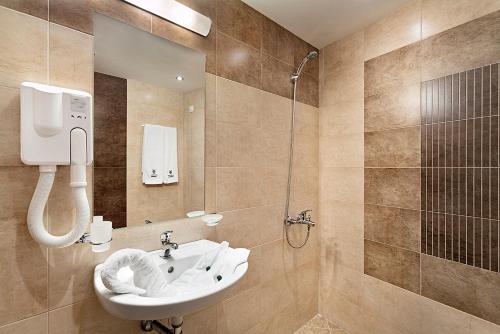 La salle de bains est pourvue d'un lavabo et d'une douche. dans l'établissement Park Hotel Moskva, à Sofia