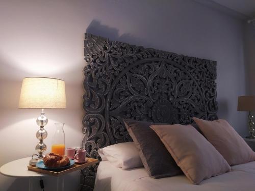a bed with a black headboard and a table with a lamp at La Parada de Echegaray in Zaragoza