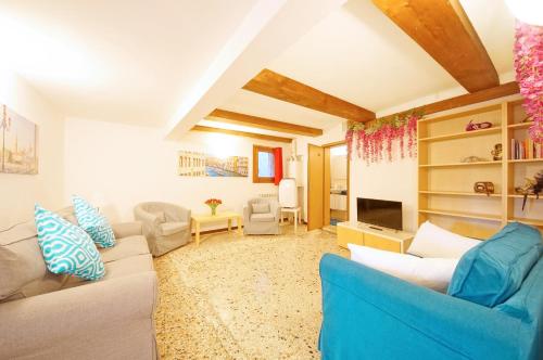 een woonkamer met een blauwe bank en stoelen bij Campo San Polo Apartment Rialto in Venetië