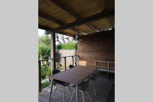 une table et des chaises en bois sur une terrasse dans l'établissement Le Bigorneau, à Langueux