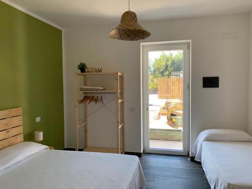 um quarto com 2 camas e uma porta de vidro deslizante em Cilento rooms em Agnone