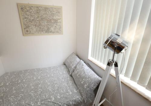 a camera in a room with a bed next to a window at Luxurious Apartment "N22" in London