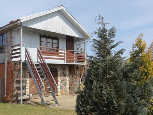 a house with a staircase on the side of it at Aizvējā in Pāvilosta