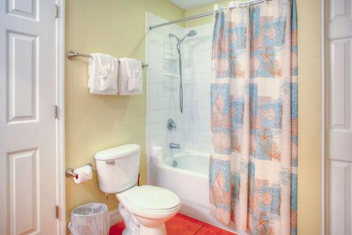 a bathroom with a toilet and a shower curtain at 305 - Madeira Bay Resort in St. Pete Beach