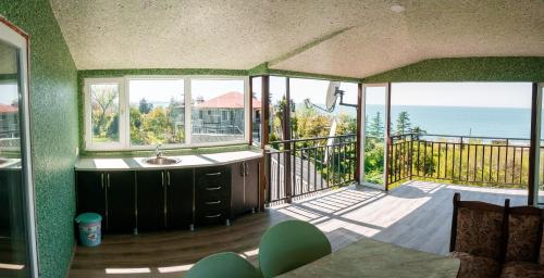 a room with a balcony with a view of the ocean at Green Garden Hotel in Makhinjauri