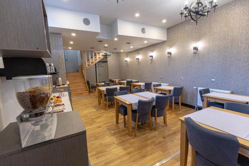 a dining room with tables and blue chairs at So&sol boutique Hotel, Tuzla in Tuzla