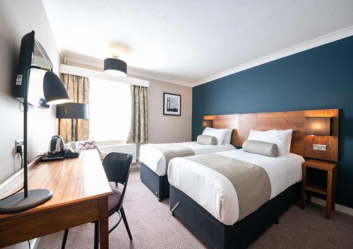 a hotel room with two beds and a desk at Toby Carvery Exeter M5 J30 by Innkeeper's Collection in Exeter