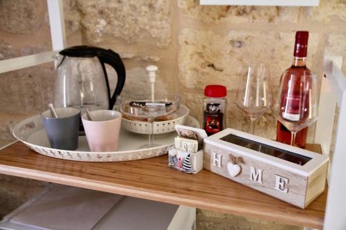 a wooden shelf with dishes and wine bottles on it at La Stanza in Bari