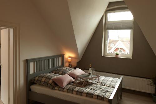 een slaapkamer met een bed met een tafel en een raam bij Schusterbude in Bad Salzuflen