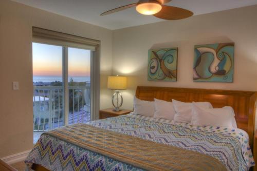 Schlafzimmer mit einem Bett und Blick auf einen Balkon in der Unterkunft 506 - Crystal Palms in St Pete Beach