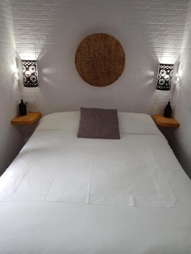 um quarto com uma grande cama branca e 2 luzes em CASA ABRIL em Vejer de la Frontera