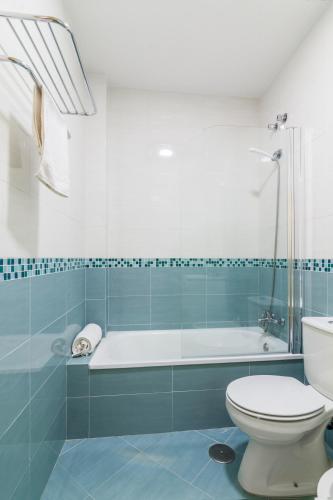 a bathroom with a toilet and a bath tub at Apartamentos Montedunas in Barbate