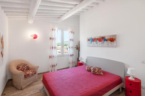 Un dormitorio con una cama roja y una silla. en Elena, en Marina di Campo