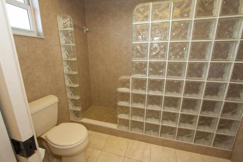 een badkamer met een toilet en een douche met glazen blokken bij 408 - Sea Breeze in St Pete Beach