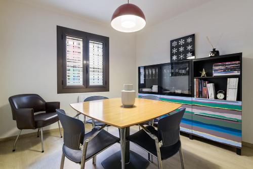 comedor con mesa, sillas y TV en Apartamento Escapada, en Andorra la Vella