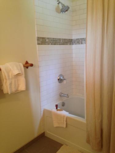 a bathroom with a tub and a shower with towels at Trail Creek Ranch in Wilson
