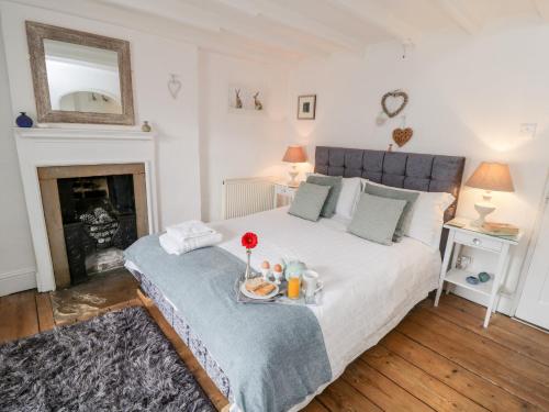 une chambre avec un lit avec un plateau de nourriture dessus dans l'établissement Dove Cottage, à Pickering