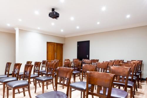 a room with rows of chairs and a podium at InnJoy Boutique Hotel in Centurion