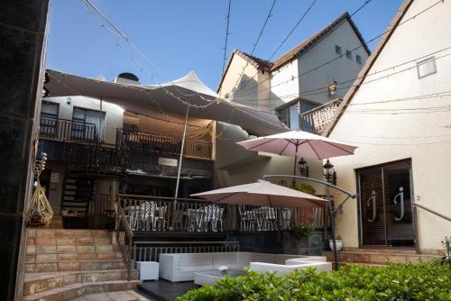 a patio with tables and umbrellas in front of a building at InnJoy Boutique Hotel in Centurion