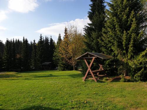 a wooden picnic table in a field with trees at Berghotel Drei Brüder Höhe in Marienberg