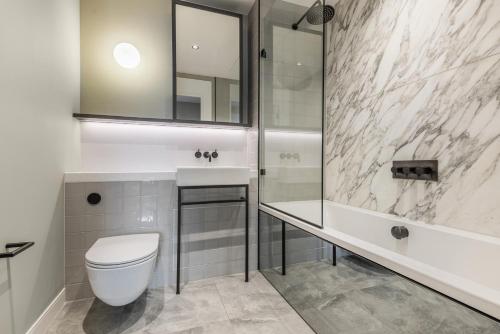 a bathroom with a toilet and a sink and a shower at Luxury River View Greenwich Apartment in London