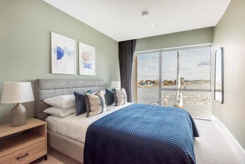 a bedroom with a bed and a large window at Luxury River View Greenwich Apartment in London