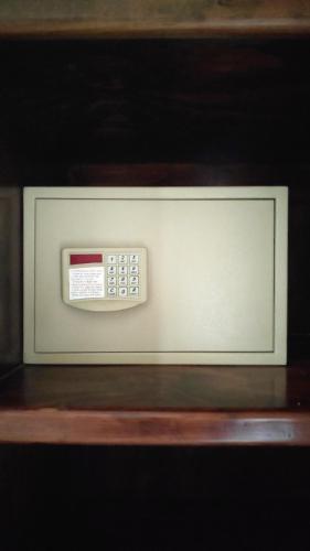 a microwave oven with a remote control on a shelf at Hotel Los Frailes, Valladolid, Yucatán in Valladolid