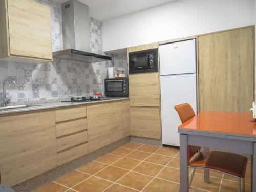 リオパルにあるCasa rural LAS TABLAS IIのキッチン(木製キャビネット、白い冷蔵庫付)