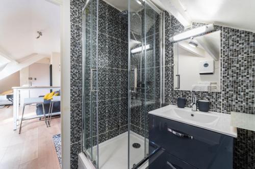 une salle de bain avec une douche en verre et un lavabo dans l'établissement APARTEO - Stade de France 15min - Parc des expositions - Paris 17min, à Aulnay-sous-Bois