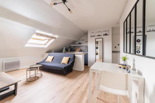 un salon avec un lit et une table dans l'établissement APARTEO - Stade de France 15min - Parc des expositions - Paris 17min, à Aulnay-sous-Bois